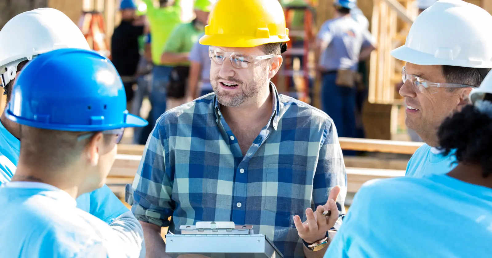 construction professional on a work site with a yellow hard hat and in a group of men